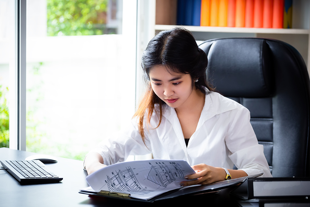Nhân viên áo trắng đang xem tài liệu báo cáo thuế